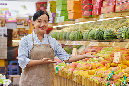 水果店中年女性店员推销水果形象图片