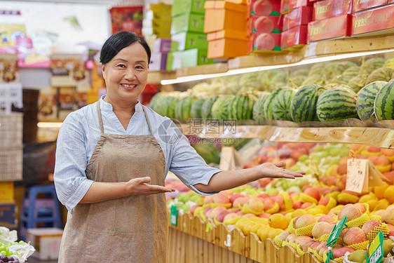 水果店中年女性店员推销水果形象图片