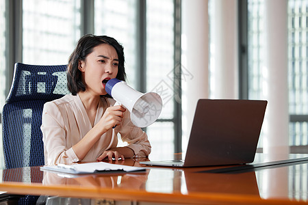 职场女性拿着扩音器对着电脑大叫图片