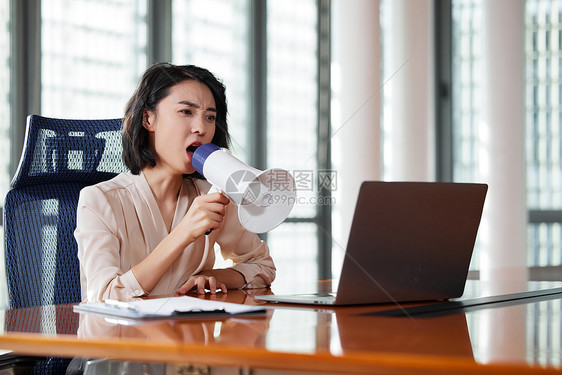 职场女性拿着扩音器对着电脑大叫图片