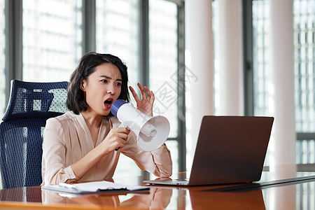 职场女性拿着扩音器对着电脑大叫图片