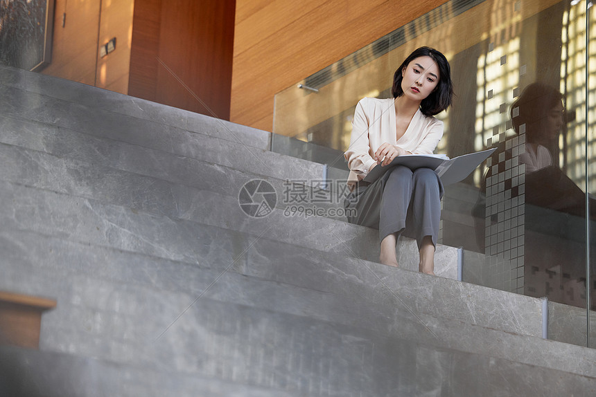 坐在楼梯上心情不好的商务女性图片