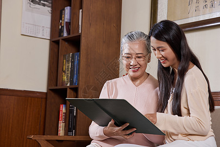 女青年陪伴年迈老奶奶看平板电脑图片