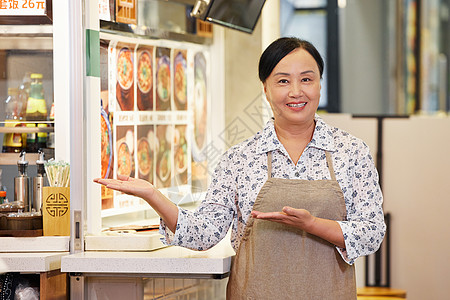 在面馆门口宣传的中年店员图片