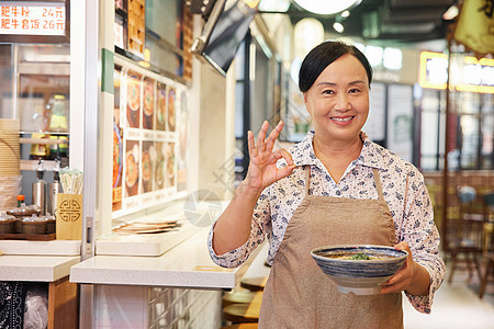 手端牛肉面的中年店员比ok手势图片