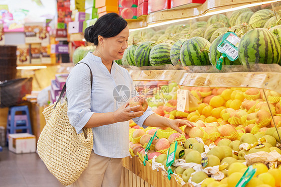 水果店内中年妇女挑选苹果图片