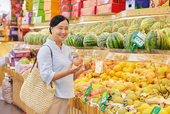 水果店内中年妇女挑选苹果图片