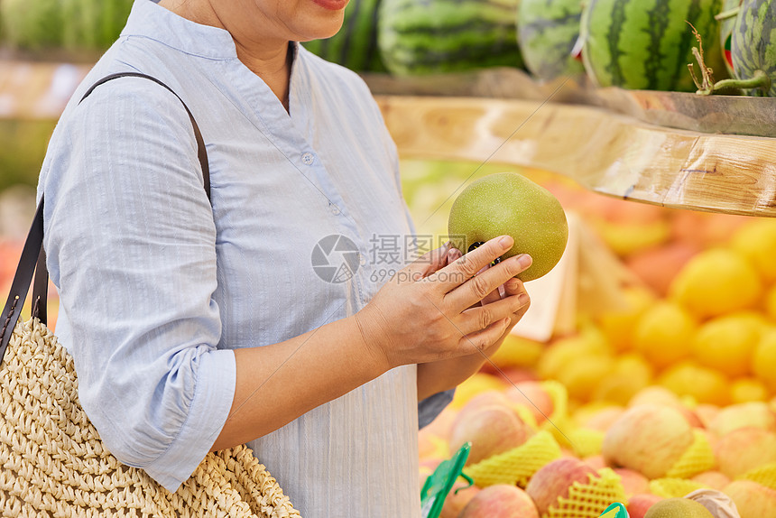 手拿苹果的中年妇女特写图片