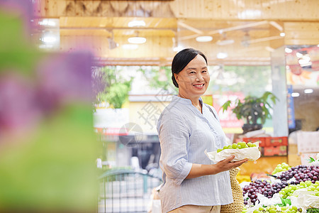 中年女性水果店内挑选水果图片