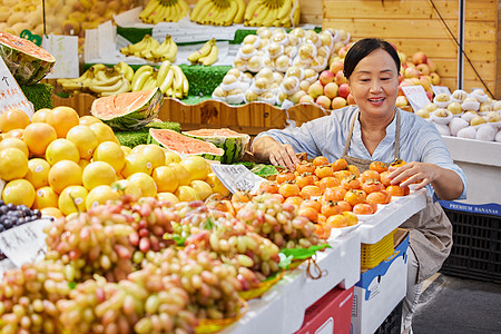 水果店员工检查水果品质背景图片