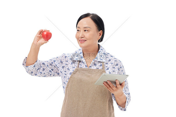 菜市场阿姨手拿番茄核对图片