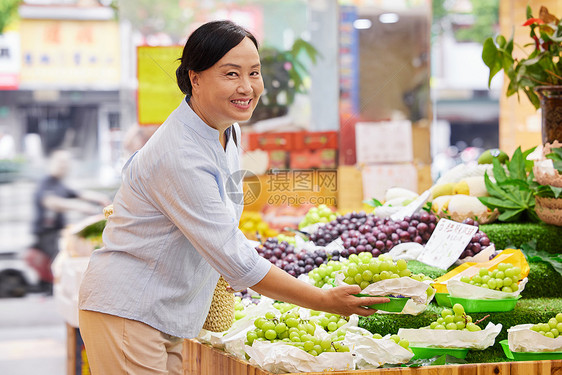 中年女性水果店内挑选水果图片