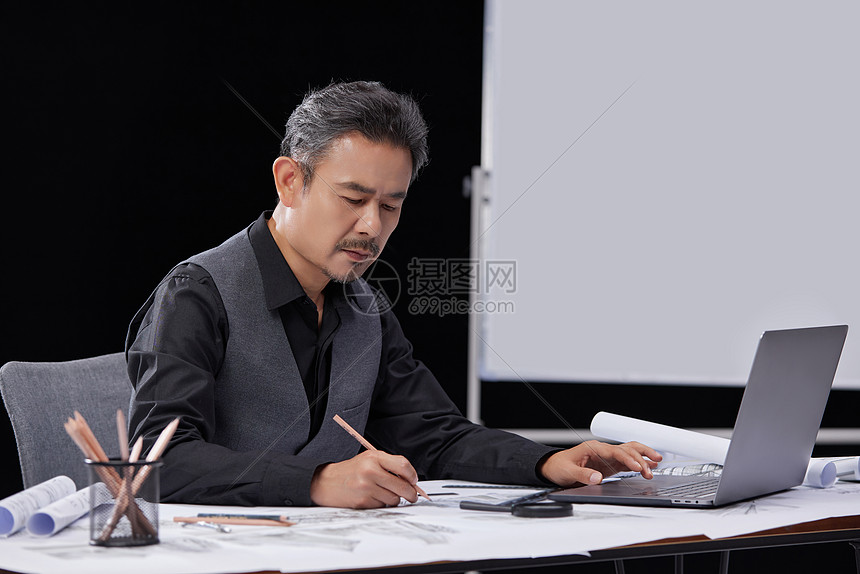建筑设计师使用电脑与纸张图片