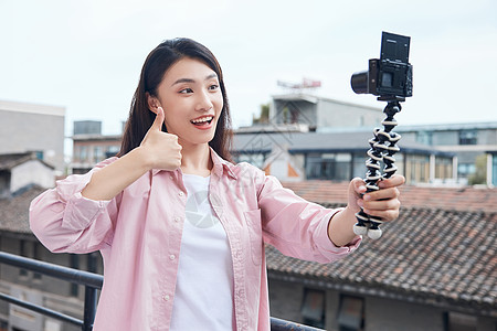 国庆节女视频博主拿相机户外拍摄背景