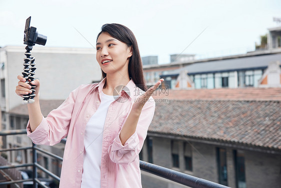 女视频博主拿相机户外拍摄图片