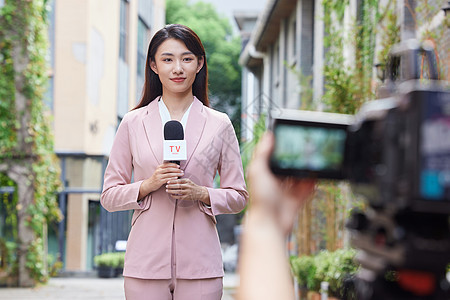 年轻女记者户外录制背景图片