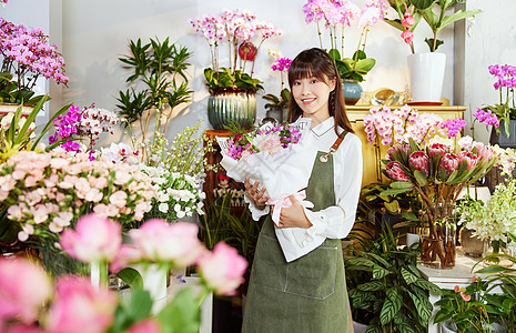 鲜花店美女销售员手捧鲜花图片