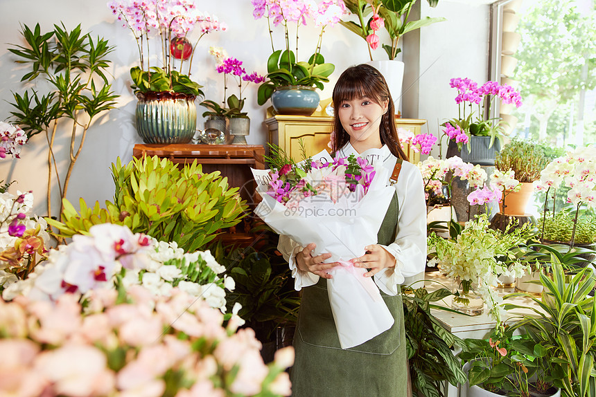 花艺店美女服务员手捧鲜花花束图片