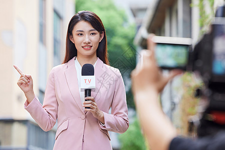 新闻采访年轻女记者户外录制背景