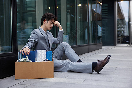 失业职场商务男性瘫坐在地上图片
