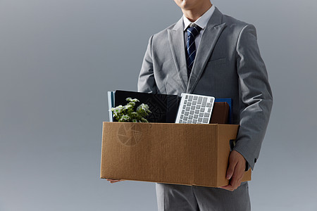 商务男性被开除抱着办公用品纸箱特写图片