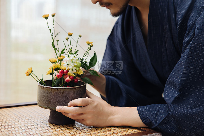 日系男性手拿花枝插花特写图片