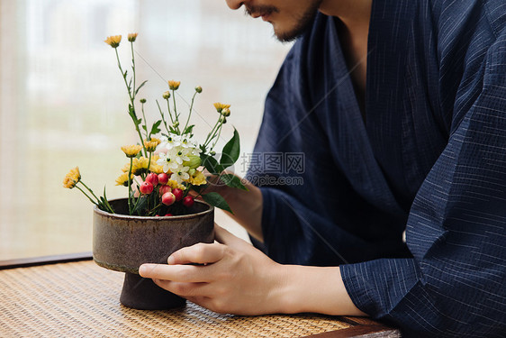 日系男性手拿花枝插花特写图片