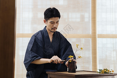 男性花艺师使用剪刀修剪花枝背景图片