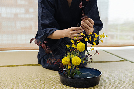 日式花艺师调整花枝特写图片