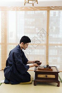 日系男性擦拭茶具图片