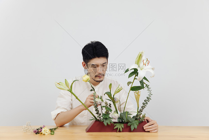 男性花艺师调整花枝插花图片