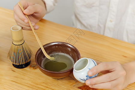 茶艺师使用茶勺取抹茶粉特写图片