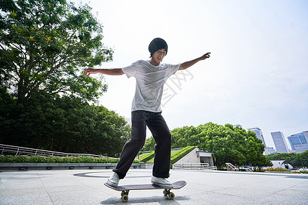 青年男性户外玩滑板图片