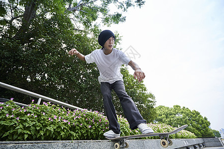 青年男性户外玩滑板图片