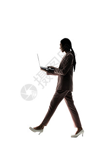 商务人士走路使用笔记本电脑办公的职场女性剪影背景