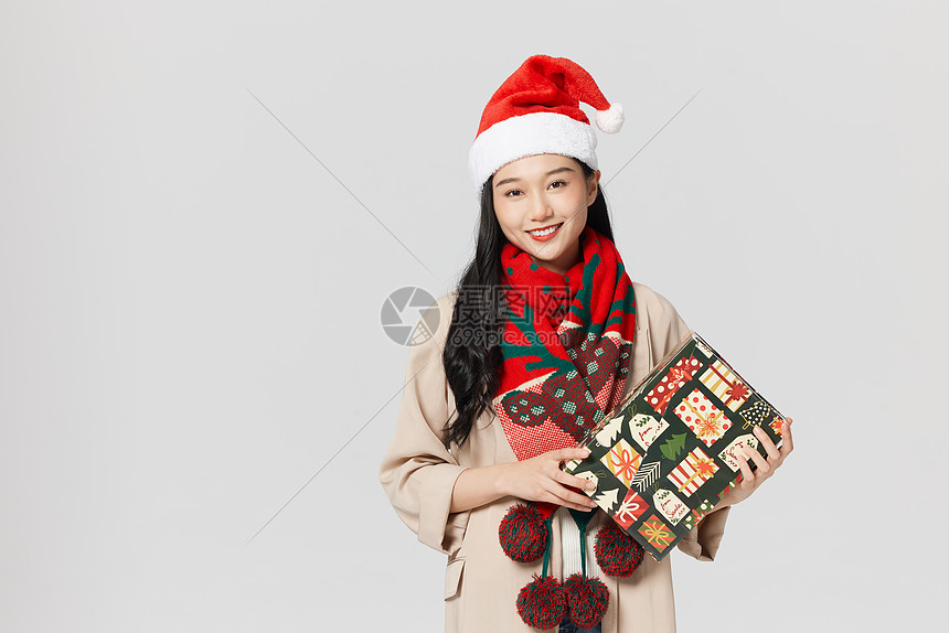 圣诞节手拿礼物的年轻女性形象图片