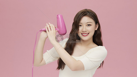 活力韩系女性手拿吹风机图片