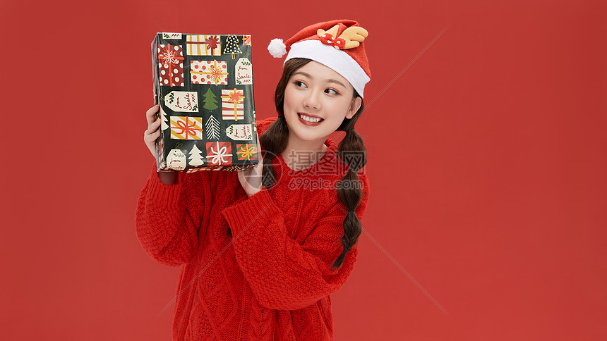 甜美女孩手拿礼物盒过圣诞节图片