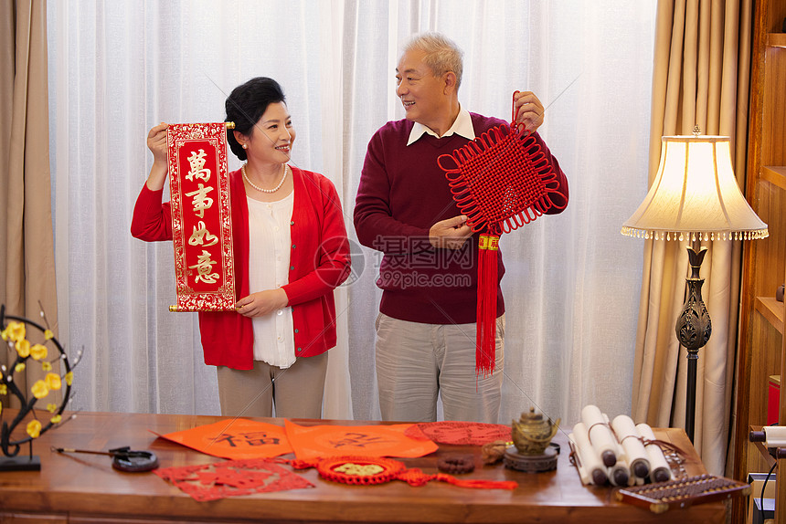 手拿春联和中国结的老年夫妇形象图片