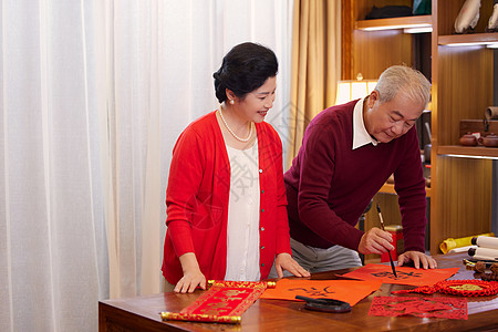 夫妻老人过年老年夫妻一起在家写福字背景