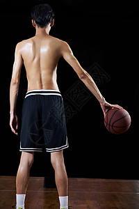 篮球青年爱好者背对镜头单手抓球背景