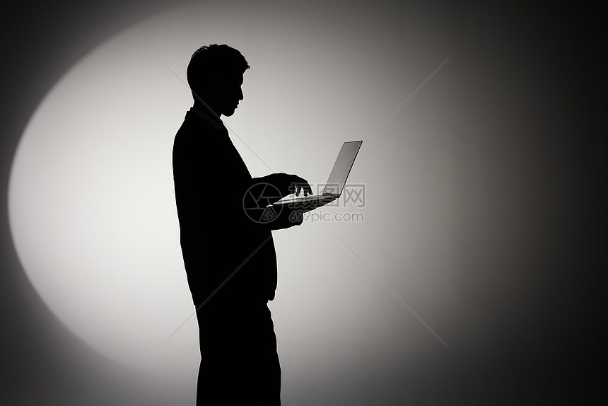 使用笔记本电脑办公的商务男性剪影高清图片下载-正版图片501799202