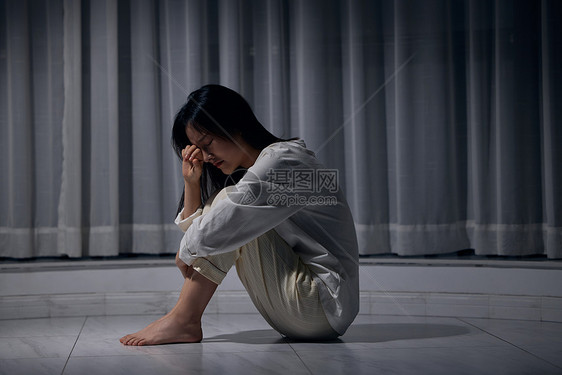 女性一个人蜷缩在地上哭泣图片