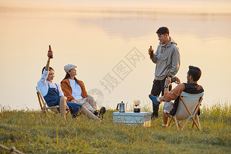 年轻人傍晚在湖边聚会聊天高清图片