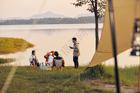 年轻人傍晚在湖边聚会聊天背景图片