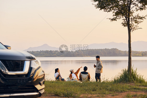 年轻人傍晚在湖边聚会聊天图片