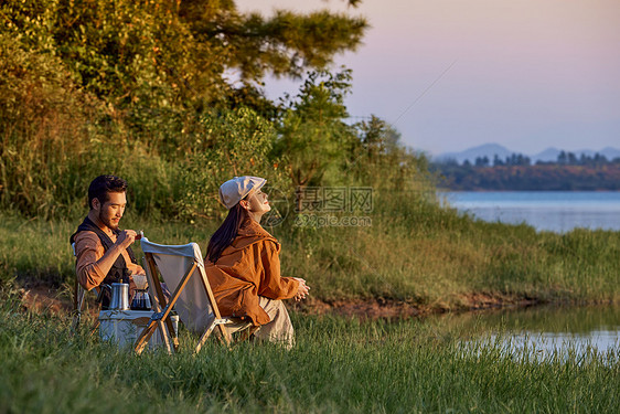 年轻情侣傍晚在湖边聚会聊天图片
