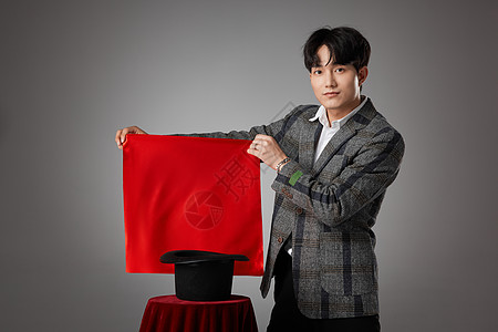 大魔术师男性魔术师手拿红色方巾正在变魔术背景