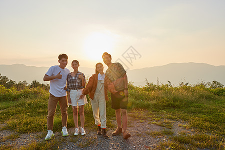 青年朋友结伴旅行看夕阳背景图片