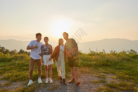 青年朋友结伴旅行看夕阳图片